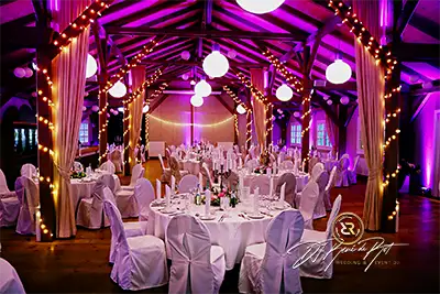 Stilvoll dekorierter Hochzeitssaal mit stimmungsvoller Beleuchtung und festlich gedeckten Tischen